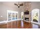 Living room featuring hardwood floors, stone fireplace and pool view at 297 Collegiate Dr, Powder Springs, GA 30127