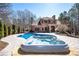A large pool and spa with a brick home and stone chimney as a backdrop at 297 Collegiate Dr, Powder Springs, GA 30127
