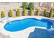 Backyard with a pool and hot tub surrounded by stone pavers, complemented by lush landscaping at 297 Collegiate Dr, Powder Springs, GA 30127
