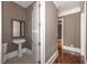 Contemporary powder room featuring pedestal sink and decorative mirror at 297 Collegiate Dr, Powder Springs, GA 30127