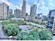 Balcony view of city buildings surrounded by lush greenery and clear skies at 3338 Peachtree Ne Rd # 1507, Atlanta, GA 30326