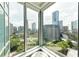 Corner window view of an impressive cityscape featuring lush green trees and several modern high rise buildings at 3338 Peachtree Ne Rd # 1507, Atlanta, GA 30326