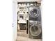 Efficient laundry area with stacked washer and dryer units and storage shelving at 3338 Peachtree Ne Rd # 1507, Atlanta, GA 30326