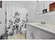Well-lit bathroom with a decorative shower curtain, updated vanity, and tile flooring at 563 Ralph Mcgill Ne Blvd, Atlanta, GA 30312