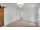 Bright bedroom features a wood sliding barn door, neutral carpet, and fresh white paint at 1610 Old Mill Xing, Marietta, GA 30062