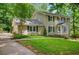 Charming two-story home with light beige siding, dark shutters, and a well-manicured front lawn with mature trees at 1610 Old Mill Xing, Marietta, GA 30062
