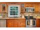 A kitchen with stainless appliances, wood cabinets, granite counters and a tile backsplash with backyard view at 1610 Old Mill Xing, Marietta, GA 30062
