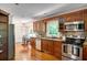 Traditional kitchen featuring wood cabinetry, stainless steel appliances, tile backsplash, and a dining area at 1610 Old Mill Xing, Marietta, GA 30062