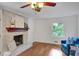 Bright living room with a brick fireplace, hardwood floors, and a large window with a view to the outside at 1610 Old Mill Xing, Marietta, GA 30062