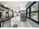 Modern kitchen boasts stainless appliances, black countertops, white cabinets, and a breakfast bar with seating at 1853 Pinedale Pl, Decatur, GA 30032