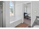 Bright bathroom with a soaking tub beneath a large arched window and view to the bedroom at 4021 Melvin Sw Dr, Atlanta, GA 30331