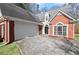 Charming brick home with attached garage, arched windows, and manicured landscaping at 4021 Melvin Sw Dr, Atlanta, GA 30331