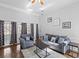 Bright living room featuring hardwood floors, neutral paint, large windows, and a cozy seating area at 4021 Melvin Sw Dr, Atlanta, GA 30331