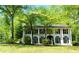 Beautiful white two-story home featuring black shutters and columns with mature landscaping at 909 Ne Otter Way Ne Way, Marietta, GA 30068