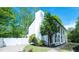 Charming white home with brick chimney, lush landscaping, and white privacy fence at 909 Ne Otter Way Ne Way, Marietta, GA 30068