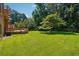 Expansive backyard with lush lawn, mature trees, and a charming wooden deck, perfect for outdoor enjoyment at 1159 Midland Nw Dr, Acworth, GA 30102