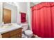 Bathroom features a single sink vanity, toilet, and shower with red shower curtain at 1159 Midland Nw Dr, Acworth, GA 30102