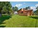 Back exterior of the house showcasing a spacious yard and a wooden deck, great for outdoor entertainment at 1159 Midland Nw Dr, Acworth, GA 30102