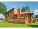 Back exterior view of a home featuring a spacious wooden deck and a well-maintained lawn, perfect for outdoor activities at 1159 Midland Nw Dr, Acworth, GA 30102