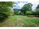 A large green backyard surrounded by trees and natural landscaping at 123 Arnold Pl, Jonesboro, GA 30236