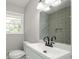 Bathroom featuring sleek fixtures, large mirror, decorative tile accent wall, and sink at 123 Arnold Pl, Jonesboro, GA 30236