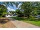 Charming single-story home with a well-manicured front yard and long driveway, framed by lush trees and greenery at 123 Arnold Pl, Jonesboro, GA 30236