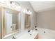 Bathroom featuring double sinks, framed mirrors, a garden tub, and updated lighting at 2427 Camata, Marietta, GA 30066