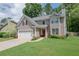 Inviting home featuring a lush green lawn, a two-car garage, and classic architectural details at 2427 Camata, Marietta, GA 30066