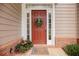 Close-up of a welcoming front door with sidelights, a wreath, and colorful potted flowers at 2427 Camata, Marietta, GA 30066