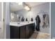 Bathroom featuring double sinks, vanity with cabinet space, framed mirror, and modern lighting at 3931 Fireoak Dr, Decatur, GA 30032