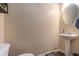 Cozy half bathroom featuring a pedestal sink, round mirror, and neutral wall color at 3931 Fireoak Dr, Decatur, GA 30032