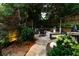 Backyard featuring a stone patio with seating, landscaping, and ambient lighting at 796 Piedmont Ne Way, Atlanta, GA 30324