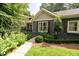 Beautifully landscaped front yard with mature trees, shrubs, and lush grass, and covered porch with seating at 796 Piedmont Ne Way, Atlanta, GA 30324