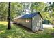 Well-maintained exterior features a lush lawn and a deck, creating an inviting outdoor space nestled among mature trees at 90 Lake Avalon Ct, Dallas, GA 30157