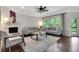 Bright living room features a fireplace, ceiling fan and views of the outdoors at 1105 Sterling Brooke Dr, Alpharetta, GA 30022