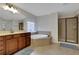 Bright main bathroom features a corner soaking tub, walk-in shower, and dark wood cabinets at 1105 Sterling Brooke Dr, Alpharetta, GA 30022