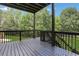 View of the black-stained wooden patio overlooking a lush green yard and mature trees at 1105 Sterling Brooke Dr, Alpharetta, GA 30022