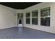 Covered patio area with white siding and a gray-stained wooden floor, offering a serene outdoor space at 1105 Sterling Brooke Dr, Alpharetta, GA 30022