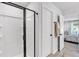 Bright bathroom featuring a walk-in shower with black trim and view to bedroom at 4563 Sweetlake Court Sw, Mableton, GA 30127