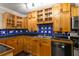 Kitchen with wood cabinetry, blue backsplash, black countertops, and stainless steel appliances at 115 Biscayne Nw Dr # E3, Atlanta, GA 30309