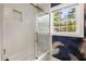 Well-lit bathroom with a glass shower, subway tile, and decorative wallpaper combining modern fixtures with elegant details at 345 Adelle Se St, Atlanta, GA 30315
