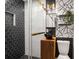 Modern bathroom with black and white patterned tile, glass shower, and wooden vanity with black sink at 345 Adelle Se St, Atlanta, GA 30315