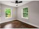 Well-lit bedroom with hardwood floors, two large windows, and neutral walls at 345 Adelle Se St, Atlanta, GA 30315