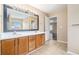 Bathroom with double sink vanity, large mirror, and neutral tile flooring at 555 Sydney Crest Ln, Lawrenceville, GA 30046