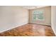 Comfortable bedroom with hardwood floors, neutral walls, and a window providing outdoor views at 555 Sydney Crest Ln, Lawrenceville, GA 30046