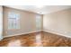 Bright bedroom featuring gleaming hardwood floors and two windows with wooded views at 555 Sydney Crest Ln, Lawrenceville, GA 30046