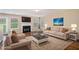 Bright living room with a fireplace, plush sofas, hardwood floors, and large windows that fill the space with natural light at 555 Sydney Crest Ln, Lawrenceville, GA 30046