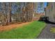 Large backyard features green lawn, surrounding woods, and a charming wooden deck at 7115 Doncaster Ct, Cumming, GA 30040
