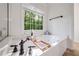 Bright bathroom showcasing a soaking tub with jets next to a large window providing natural light at 7115 Doncaster Ct, Cumming, GA 30040