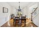 Traditional dining room with dark wood table, chandelier, and view of front yard at 7115 Doncaster Ct, Cumming, GA 30040